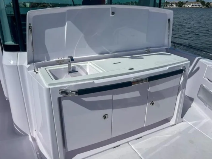  Yacht Photos Pics 2024 Axopar 37XC CROSS CABIN outdoor kitchenette with sink and storage.