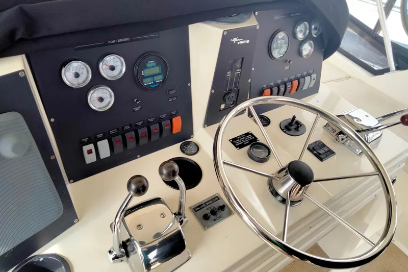 Always Right Yacht Photos Pics Control panel of a 1988 Viking 48 Convertible yacht with steering wheel and gauges.