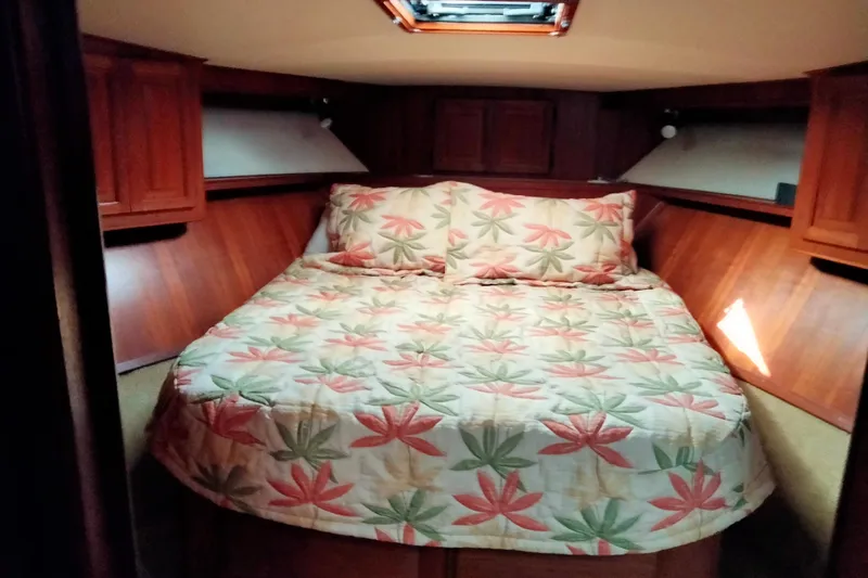 Always Right Yacht Photos Pics Cozy bedroom in 1988 Viking 48 Convertible yacht with floral bedding and wood paneling.