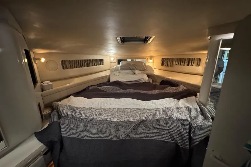  Yacht Photos Pics 1996 Sea Ray 500 Sedan Bridge cabin interior with cozy bedding and ambient lighting.
