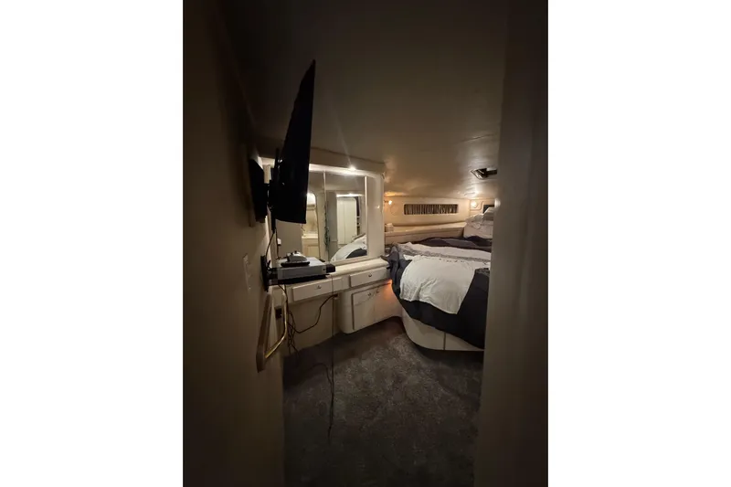  Yacht Photos Pics 1996 Sea Ray 500 Sedan Bridge cabin interior with bed, TV, and vanity area.