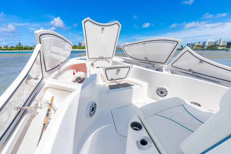  Yacht Photos Pics 2022 SeaVee 270Z boat interior with open storage compartments and seating, under clear blue sky.