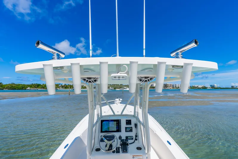  Yacht Photos Pics 2022 SeaVee 270Z boat console with rod holders, clear blue sky, and calm waters.
