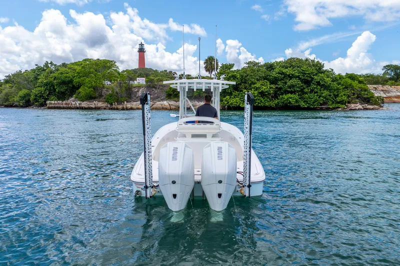  Yacht Photos Pics 2022 SeaVee 270Z boat on water near lush island and lighthouse.