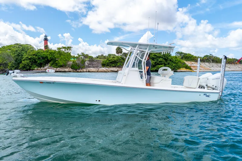  Yacht Photos Pics 2022 SeaVee 270Z boat on water, lighthouse and greenery in background, clear sky.