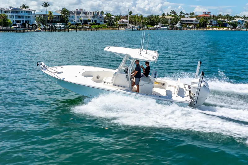  Yacht Photos Pics 2022 SeaVee 270Z boat cruising on clear blue water near coastal homes.