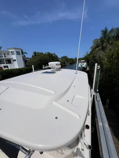  Yacht Photos Pics 2015 Grady-White Freedom 307 boat docked near lush greenery and residential area.