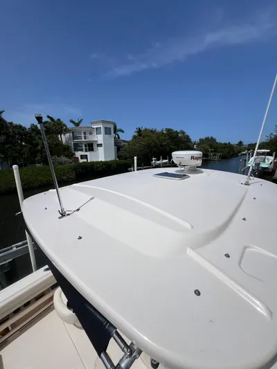  Yacht Photos Pics 2015 Grady-White Freedom 307 boat docked near waterfront homes under clear blue sky.