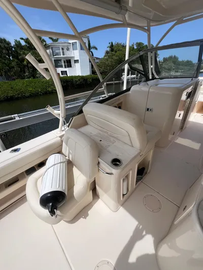  Yacht Photos Pics 2015 Grady-White Freedom 307 boat interior with seating and console, docked near waterfront homes.