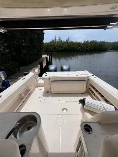  Yacht Photos Pics 2015 Grady-White Freedom 307 boat interior with dual engines, docked by a serene waterway.
