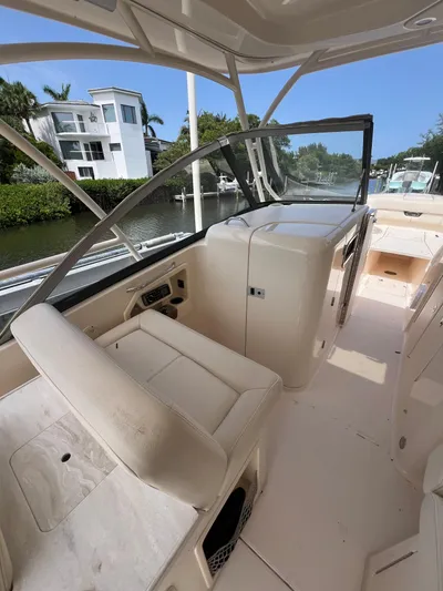  Yacht Photos Pics 2015 Grady-White Freedom 307 boat interior with seating and console, docked by waterfront homes.