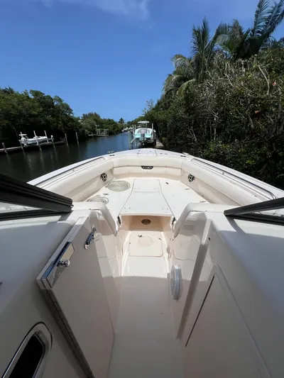  Yacht Photos Pics 2015 Grady-White Freedom 307 boat on a scenic waterway with lush greenery.
