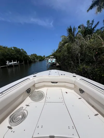  Yacht Photos Pics 2015 Grady-White Freedom 307 boat on a serene waterway with lush greenery.