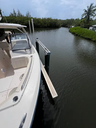  Yacht Photos Pics 2015 Grady-White Freedom 307 boat docked on a calm river with lush greenery.