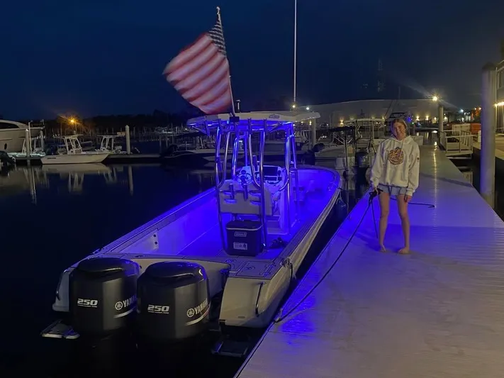  Yacht Photos Pics A Custom Shark Fin R321 boat docked at night, illuminated with blue lights.