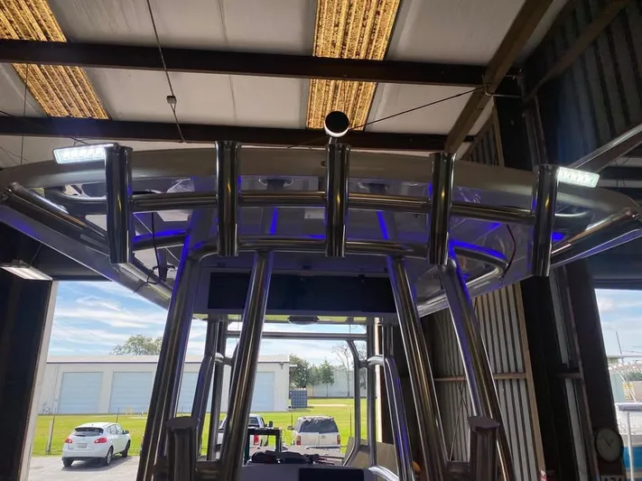  Yacht Photos Pics Custom Shark Fin R321 boat with sleek metal framework and LED lights in a garage.