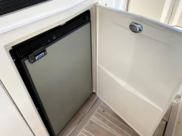  Yacht Photos Pics Azimut Atlantis Verve Outboard 2014 boat interior with open cabinet and mini fridge.