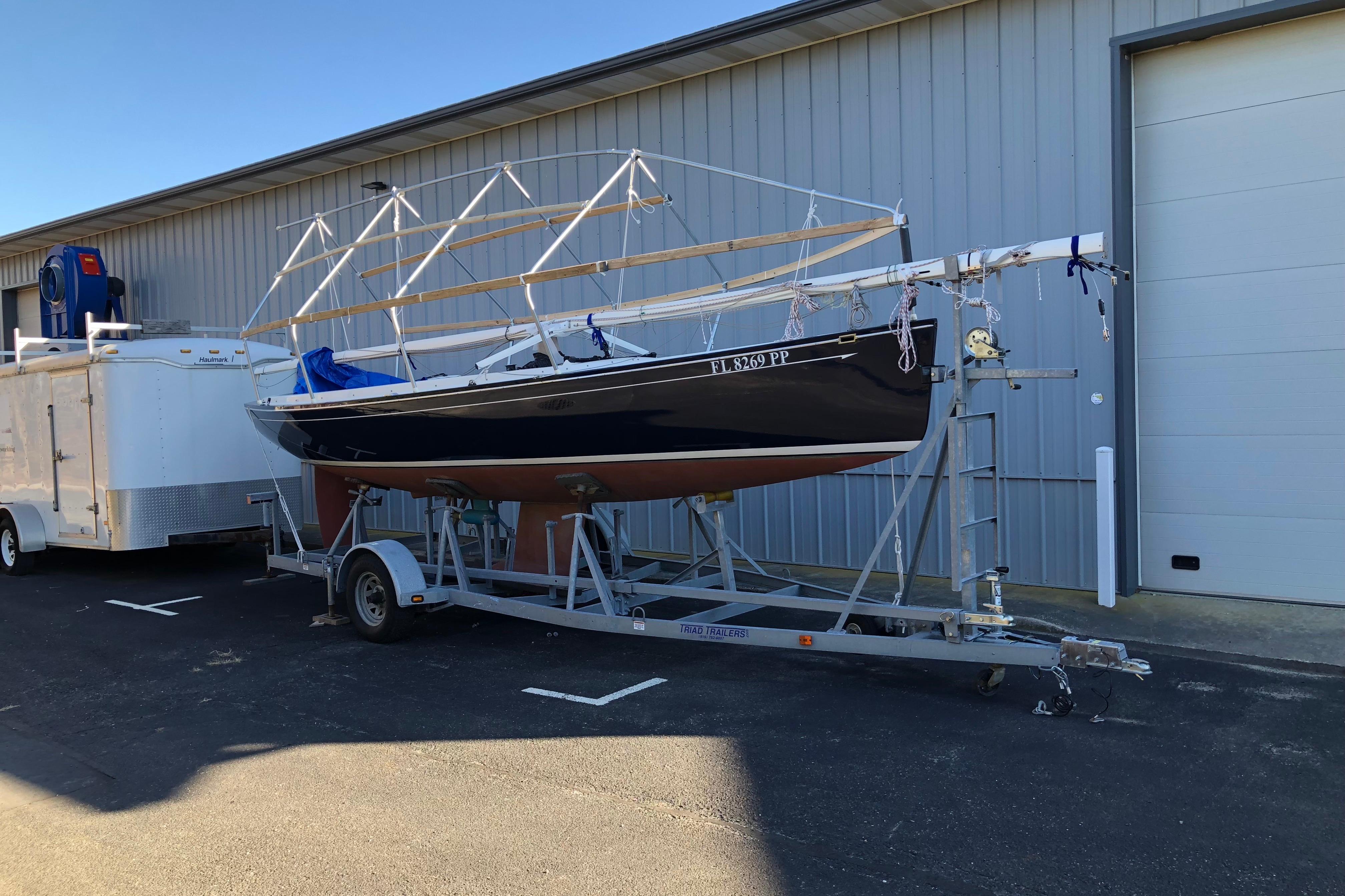2013 Saffier Se 23ft sailboat on trailer beside industrial building.