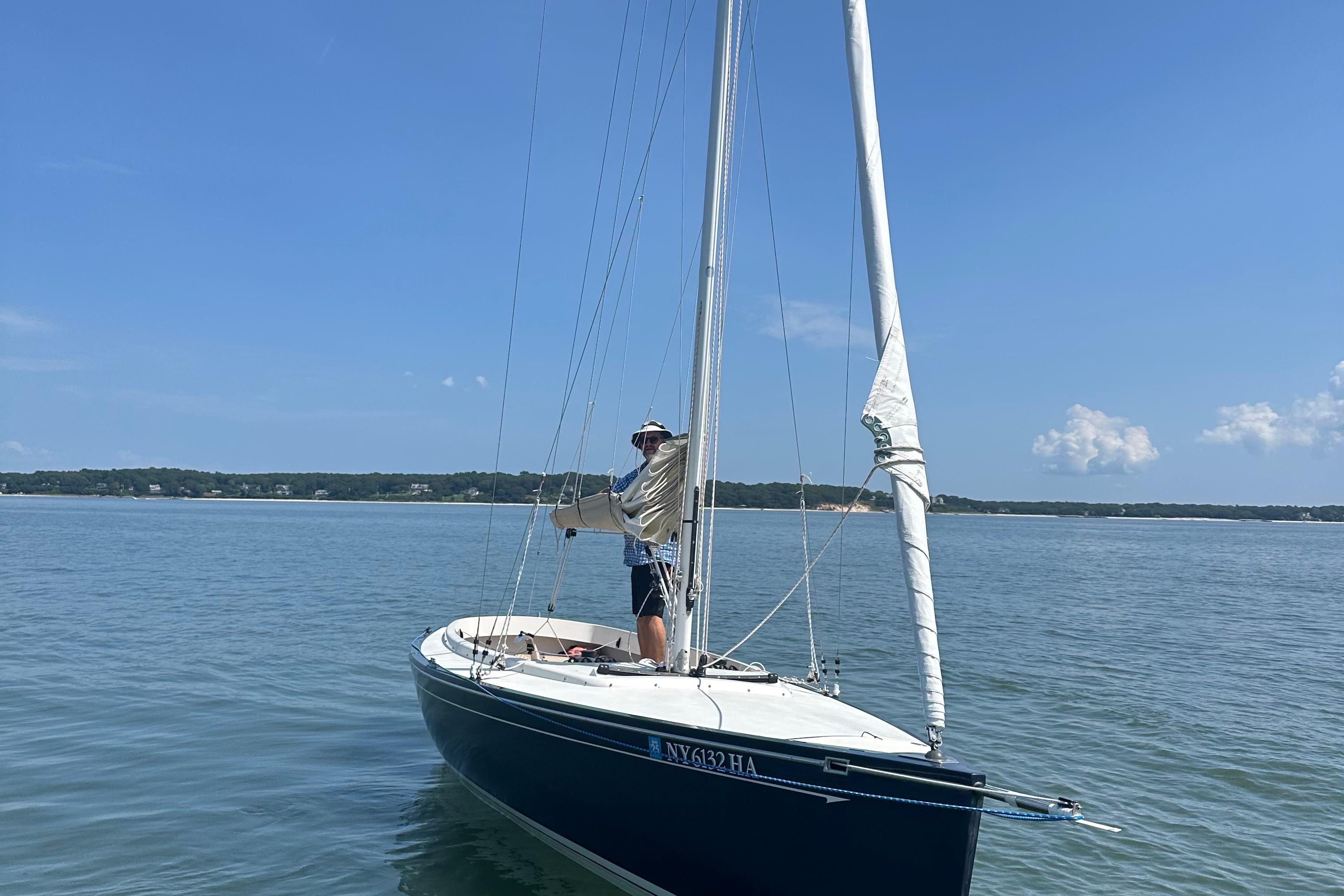 Saffier Se 23ft sailboat on calm water, 2013 model, with person adjusting sails.