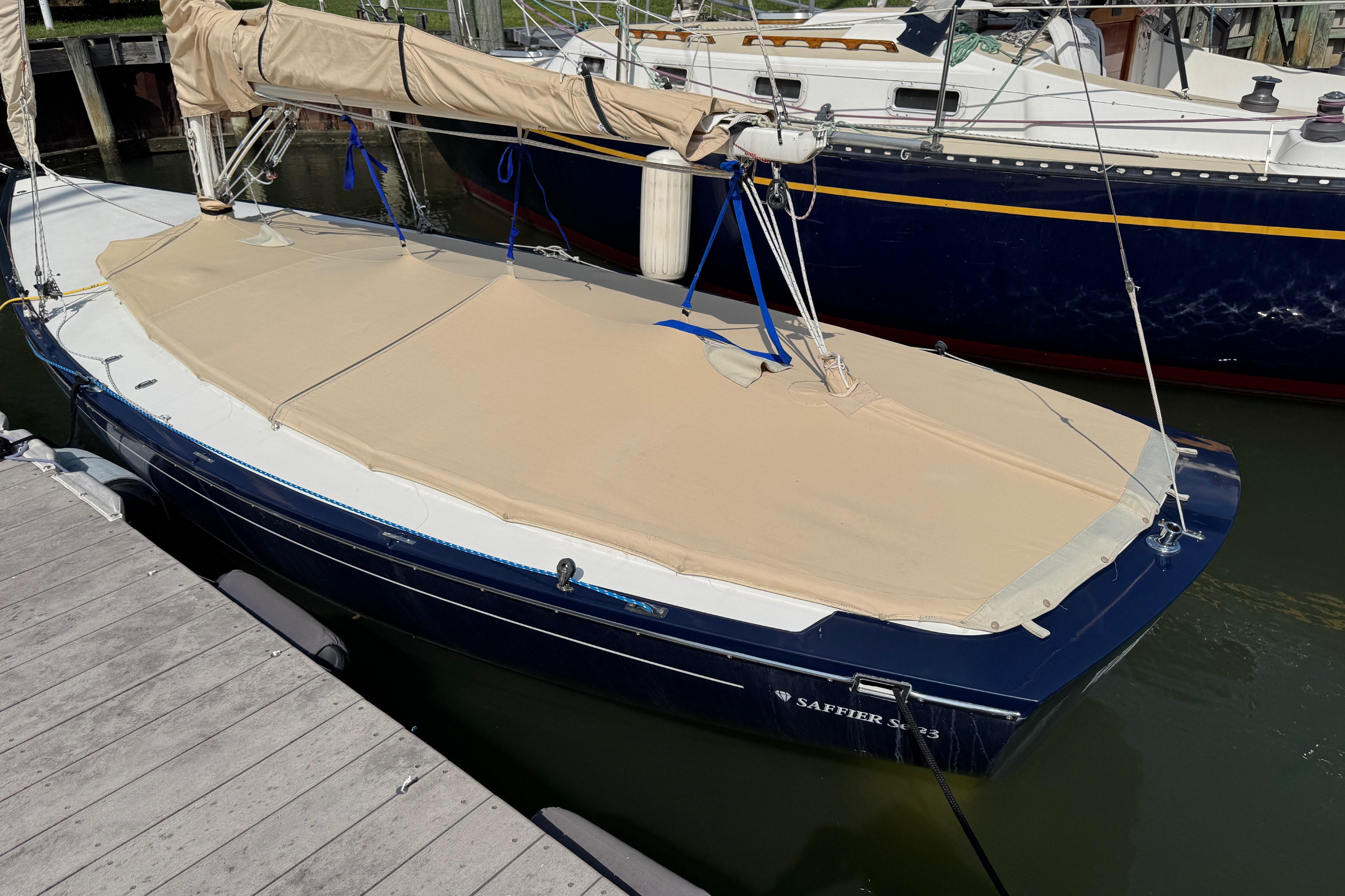 2013 Saffier Se 23ft sailboat docked, covered with beige tarp, blue hull visible.