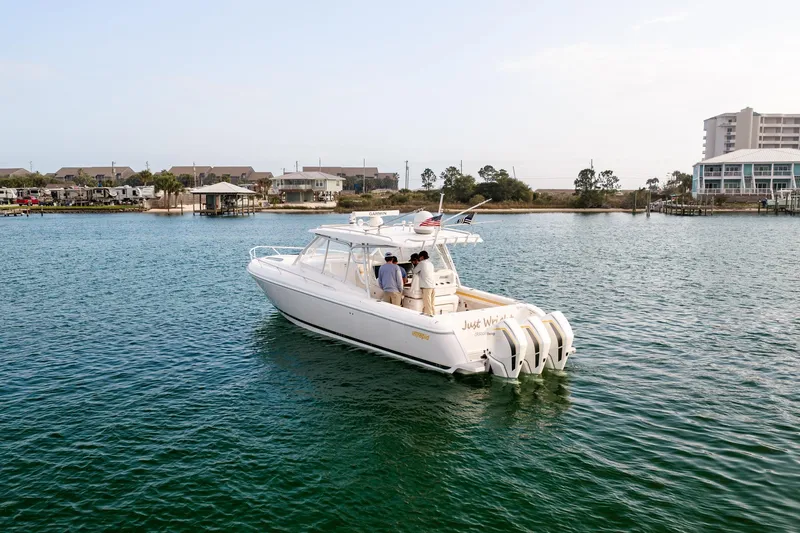  Yacht Photos Pics 2020 Intrepid 407 Cuddy boat cruising near a coastal residential area.