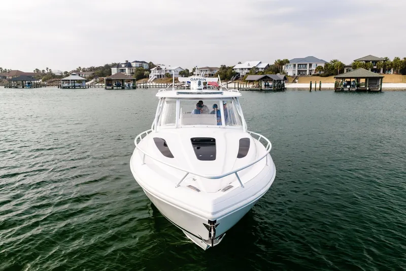  Yacht Photos Pics 2020 Intrepid 407 Cuddy boat cruising near waterfront homes.
