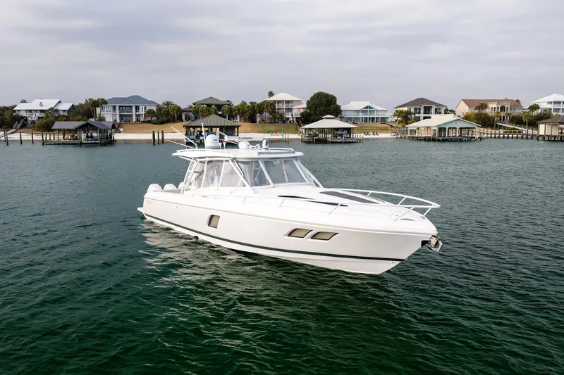  Yacht Photos Pics 2020 Intrepid 407 Cuddy boat on calm water near waterfront homes.
