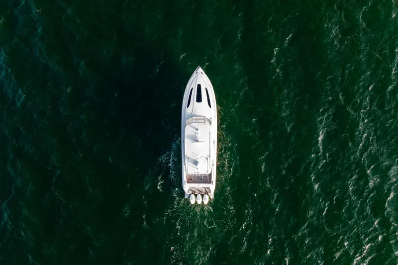  Yacht Photos Pics Aerial view of 2020 Intrepid 407 Cuddy boat cruising on green ocean waters.