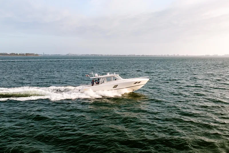  Yacht Photos Pics 2020 Intrepid 407 Cuddy cruising on open water under a cloudy sky.