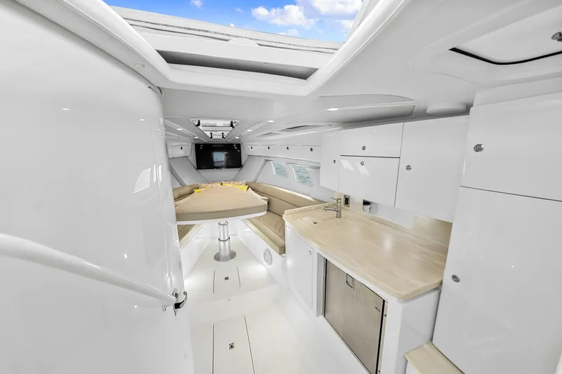  Yacht Photos Pics Interior of 2020 Intrepid 407 Cuddy boat with modern kitchen and seating area.