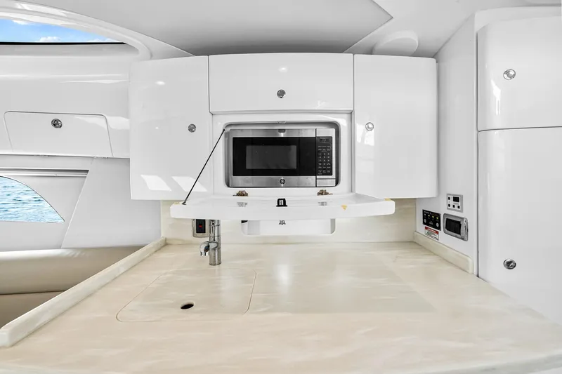  Yacht Photos Pics 2020 Intrepid 407 Cuddy interior with modern kitchenette and microwave.