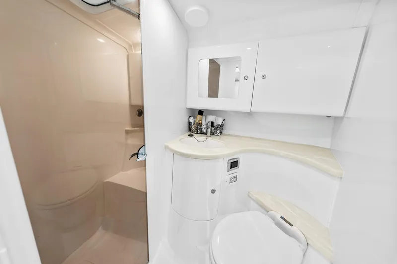  Yacht Photos Pics 2020 Intrepid 407 Cuddy boat bathroom with modern white fixtures and compact design.