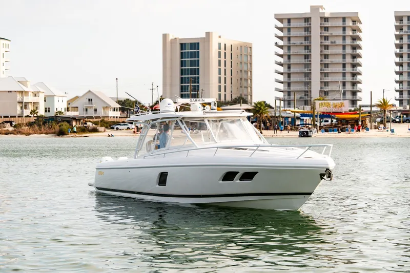  Yacht Photos Pics 2020 Intrepid 407 Cuddy boat on water near beachfront buildings.