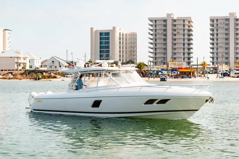  Yacht Photos Pics 2020 Intrepid 407 Cuddy boat cruising near modern beachfront buildings.