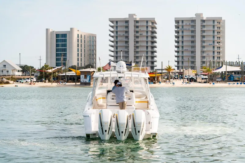  Yacht Photos Pics 2020 Intrepid 407 Cuddy boat cruising near beachfront buildings.