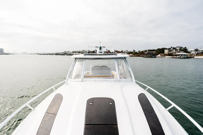  Yacht Photos Pics 2020 Intrepid 407 Cuddy boat cruising on calm waters near coastal homes.