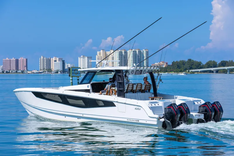  Yacht Photos Pics 2024 Aquila 47 Molokai yacht cruising near city skyline on a sunny day.