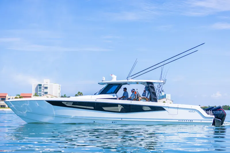  Yacht Photos Pics 2024 Aquila 47 Molokai yacht on calm water with people onboard.