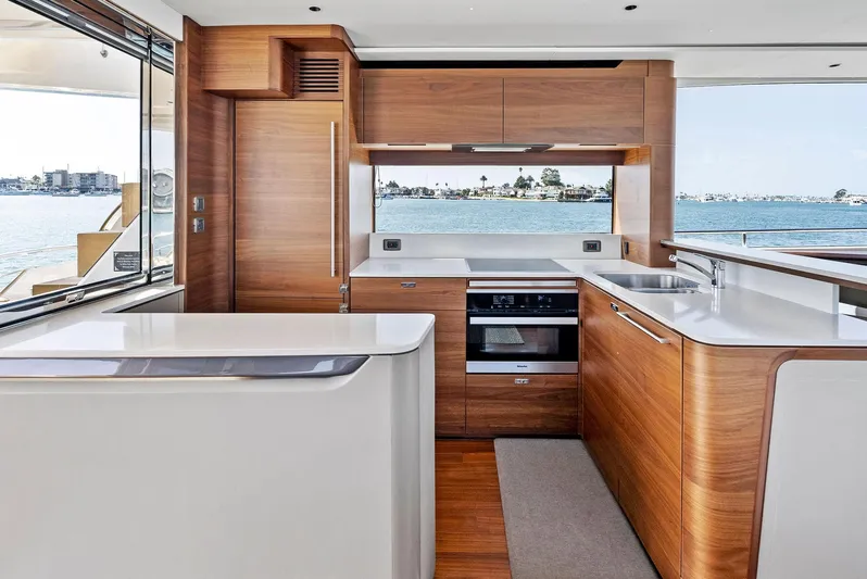 Robri Mar Yacht Photos Pics Luxurious 2023 Princess Y72 yacht kitchen with modern wood cabinetry and ocean view.