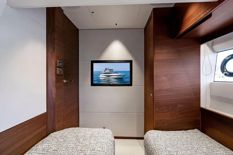 Robri Mar Yacht Photos Pics Luxurious 2023 Princess Y72 yacht cabin with twin beds and wall-mounted TV.