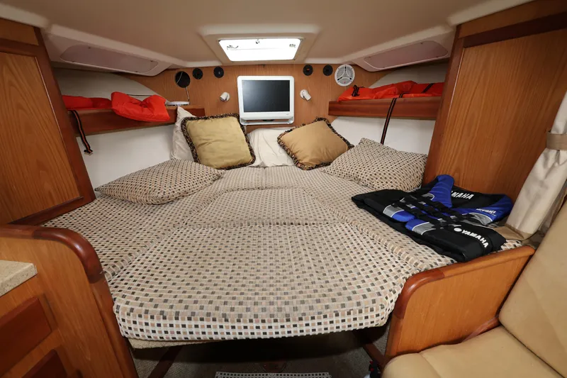 Geranomo Yacht Photos Pics 2007 Luhrs 32 Open cabin with bed, TV, and storage shelves.