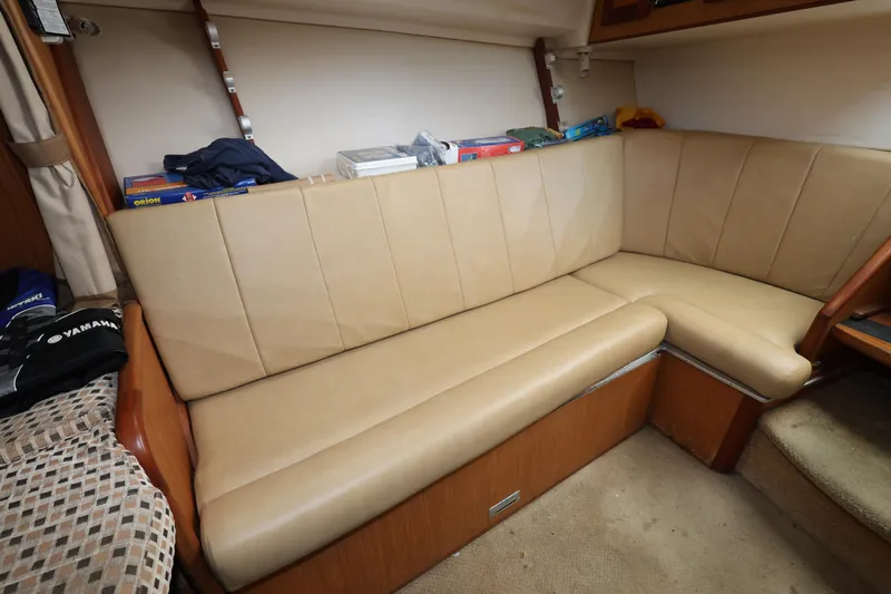 Geranomo Yacht Photos Pics 2007 Luhrs 32 Open interior seating area with beige cushions and storage shelves.