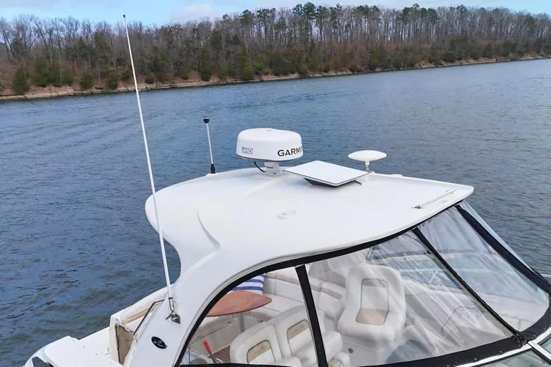  Yacht Photos Pics 2009 Sea Ray Sundancer 350 boat on a calm river with wooded shoreline.