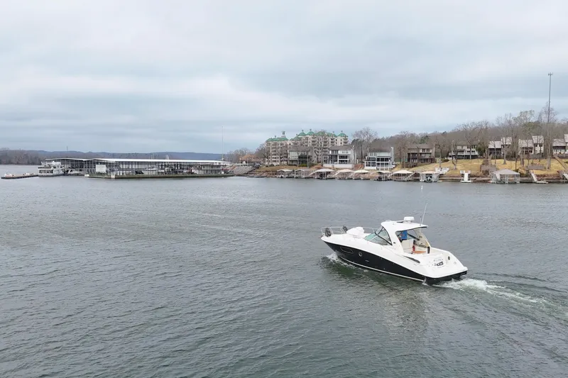  Yacht Photos Pics 2009 Sea Ray Sundancer 350 cruising on a lake near waterfront homes and marina.
