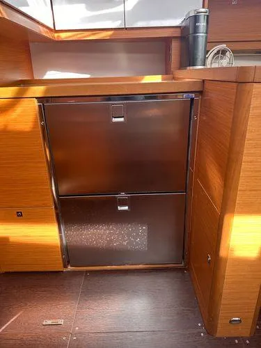 Epiphany Yacht Photos Pics Modern kitchen area in a 2022 Dufour 430 yacht, featuring sleek wooden cabinetry.