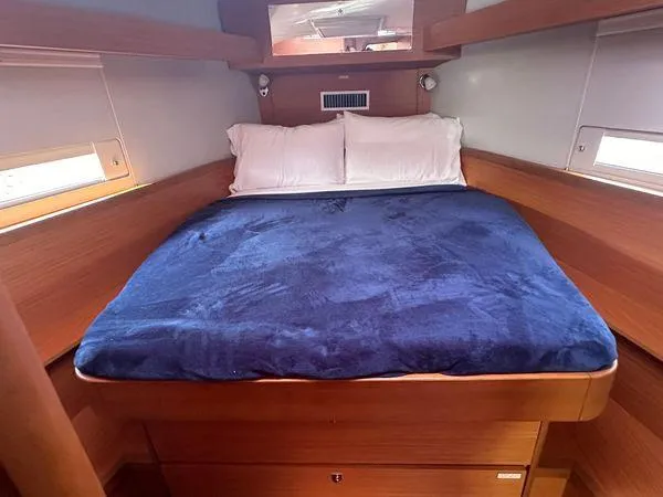 Epiphany Yacht Photos Pics Cozy cabin interior of 2022 Dufour 430 yacht with blue bedding and wooden finish.