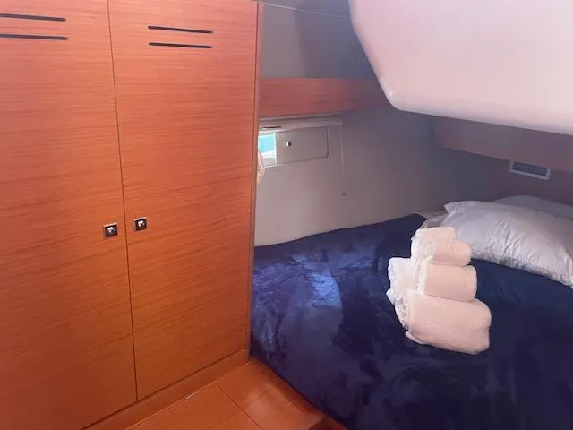 Epiphany Yacht Photos Pics Cozy cabin interior of 2022 Dufour 430 yacht with bed and wooden cabinetry.