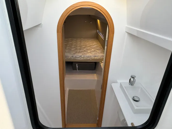 Stock Neel 47 Yacht Photos Pics Interior of 2023 NEEL 47 boat cabin with bed and sink.