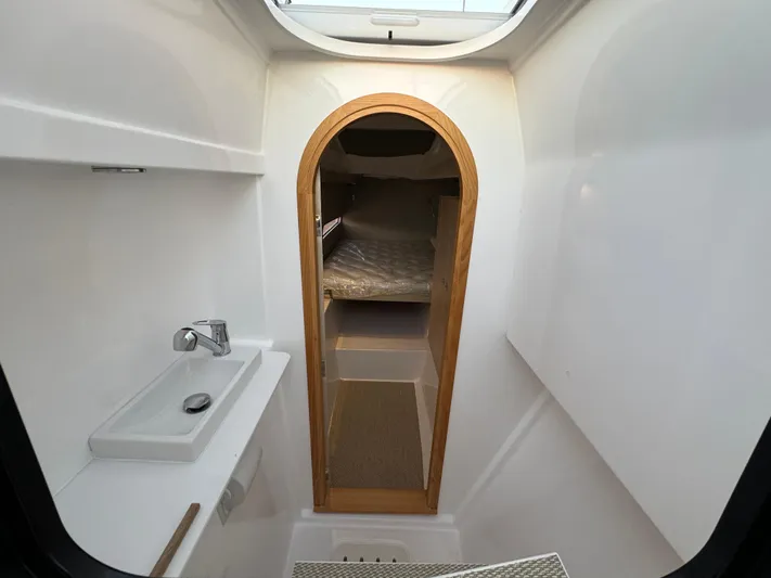 Stock Neel 47 Yacht Photos Pics Interior of 2023 NEEL 47 trimaran, featuring compact bathroom and cozy sleeping area.