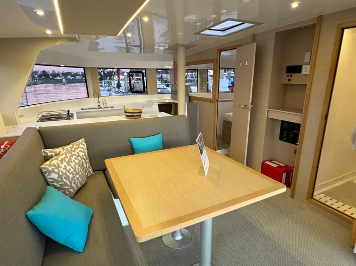 Stock Neel 47 Yacht Photos Pics Modern NEEL 47 yacht interior with dining area, cushions, and kitchenette, 2023 model.